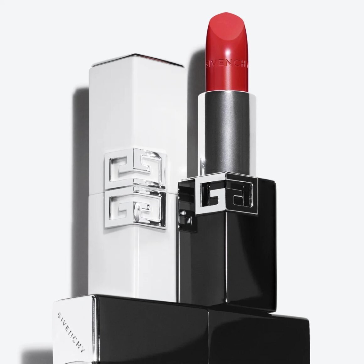 Batom vermelho aberto sobre estojos preto e branco com monograma Givenchy