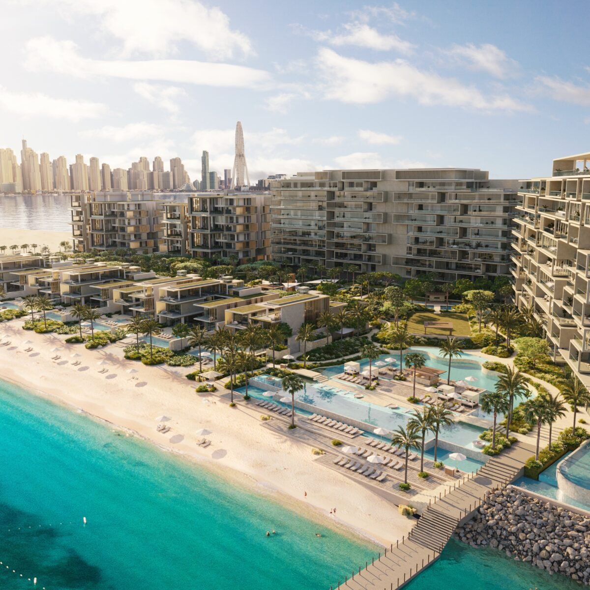 Vista aérea de resort à beira-mar, com praia, piscinas e prédios baixos diante da orla de Dubai