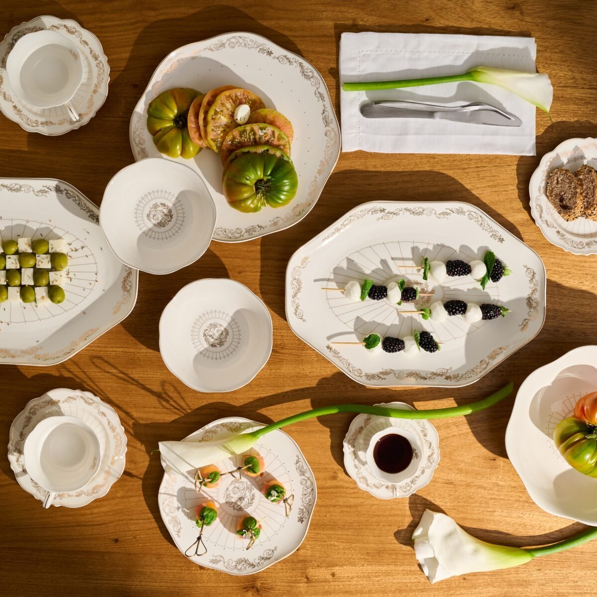 Mesa posta com porcelanas da coleção Art Nouveau da Le Lis Casa, com arabescos dourados.