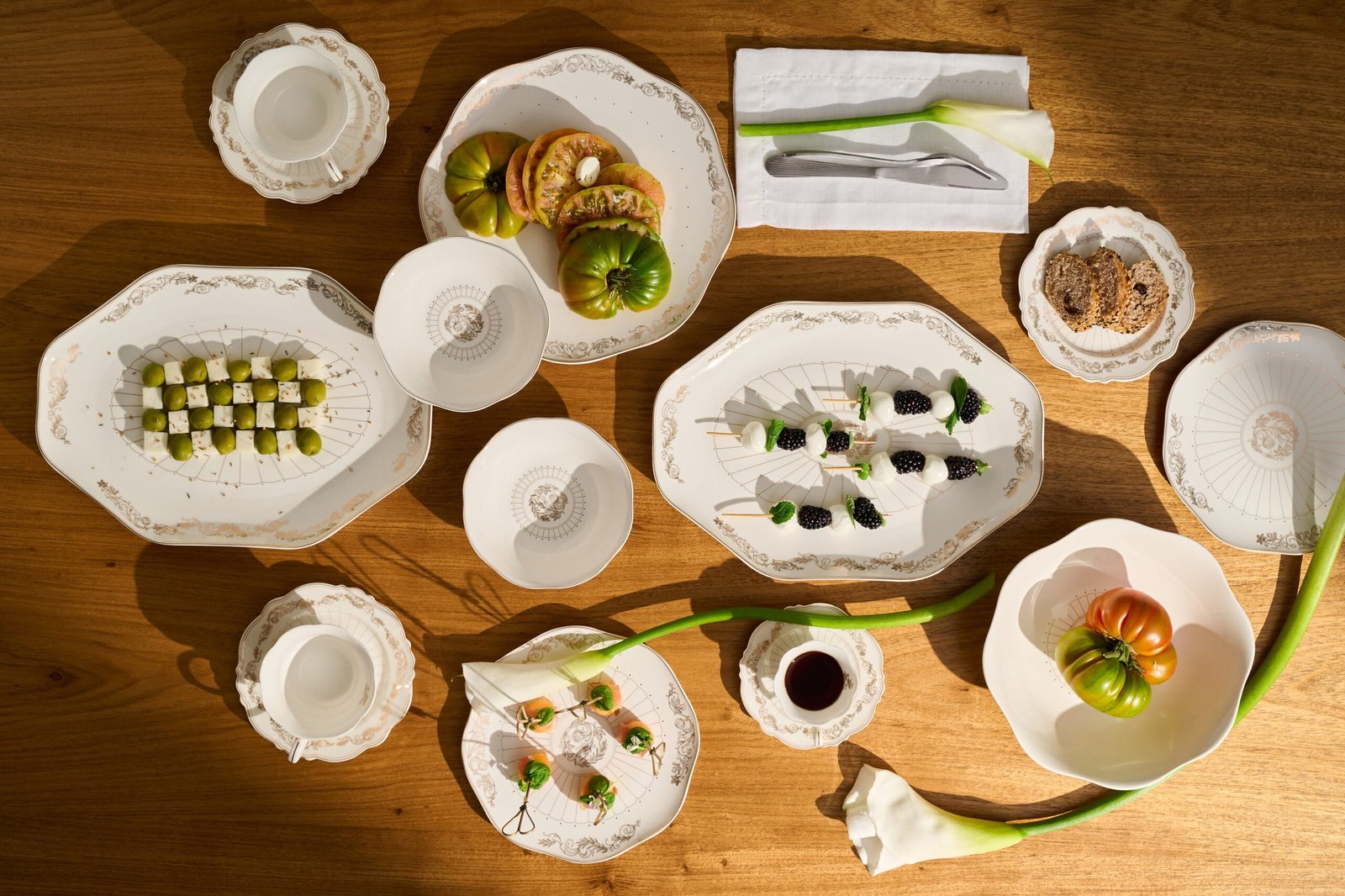 Mesa posta com porcelanas da coleção Art Nouveau da Le Lis Casa, com arabescos dourados.
