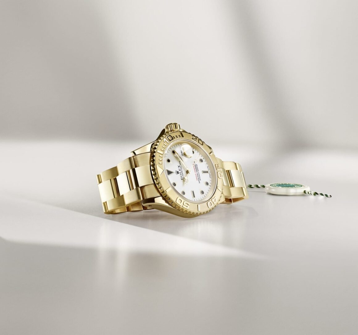 Relógio Rolex em metal dourado sobre superfície clara, ao lado de selo do programa Certified Pre-Owned.