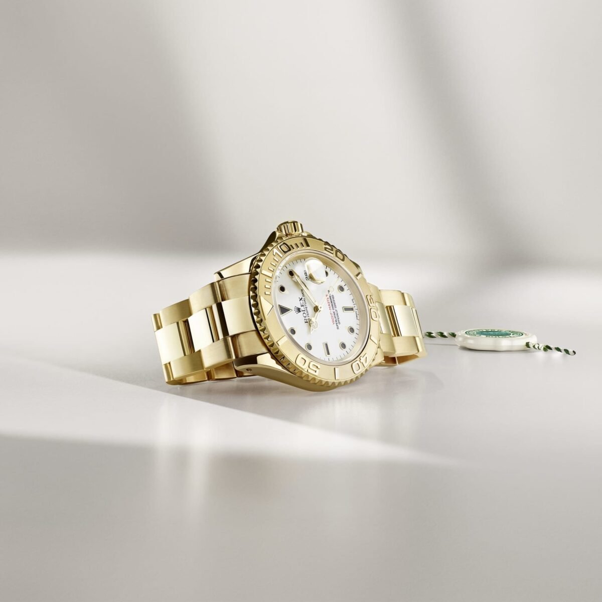 Relógio Rolex em metal dourado sobre superfície clara, ao lado de selo do programa Certified Pre-Owned.