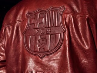 Detalhe de jaqueta AMIRI com o brasão do FC Barcelona aplicado nas costas.
