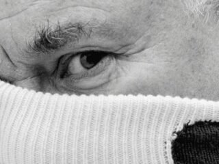 Damien Hirst segura uma malha clara diante do rosto em imagem da colaboração com a Barrie.