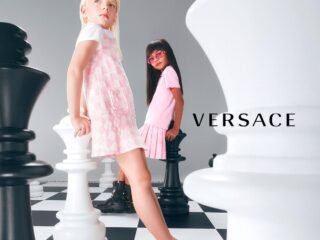 Duas crianças em campanha infantil da Versace, entre peças gigantes de xadrez