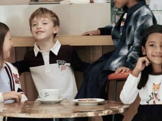 Crianças com peças da coleção Bonpoint x Maison Kitsuné reunidas em torno de uma mesa de mármore no Café Kitsuné
