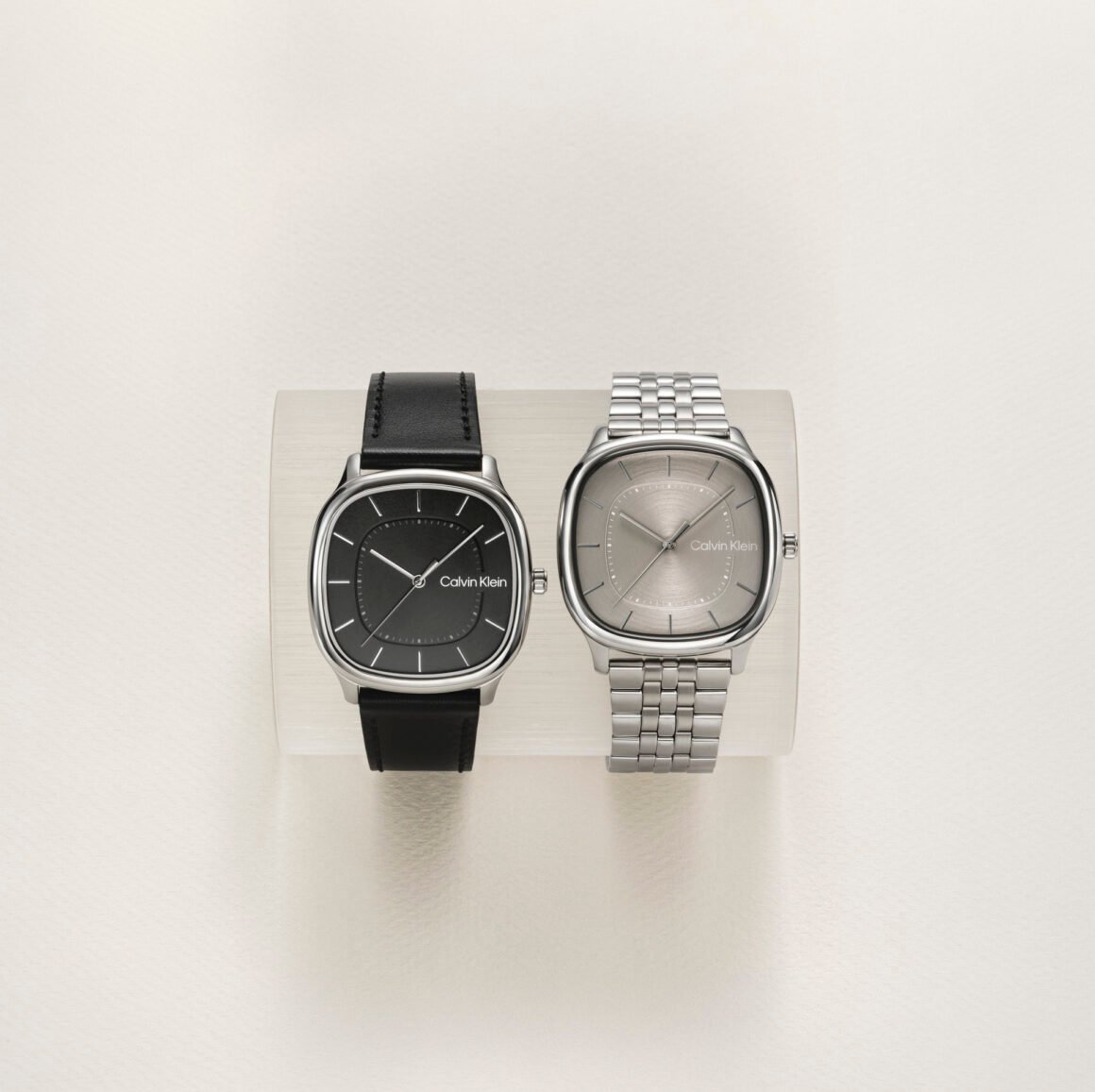 Dois relógios Calvin Klein de caixa quadrada, um com pulseira de couro preto e outro com bracelete de aço