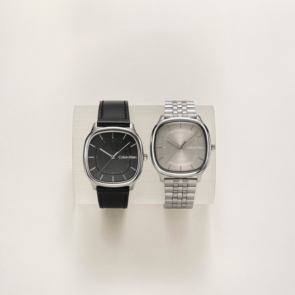 Dois relógios Calvin Klein de caixa quadrada, um com pulseira de couro preto e outro com bracelete de aço
