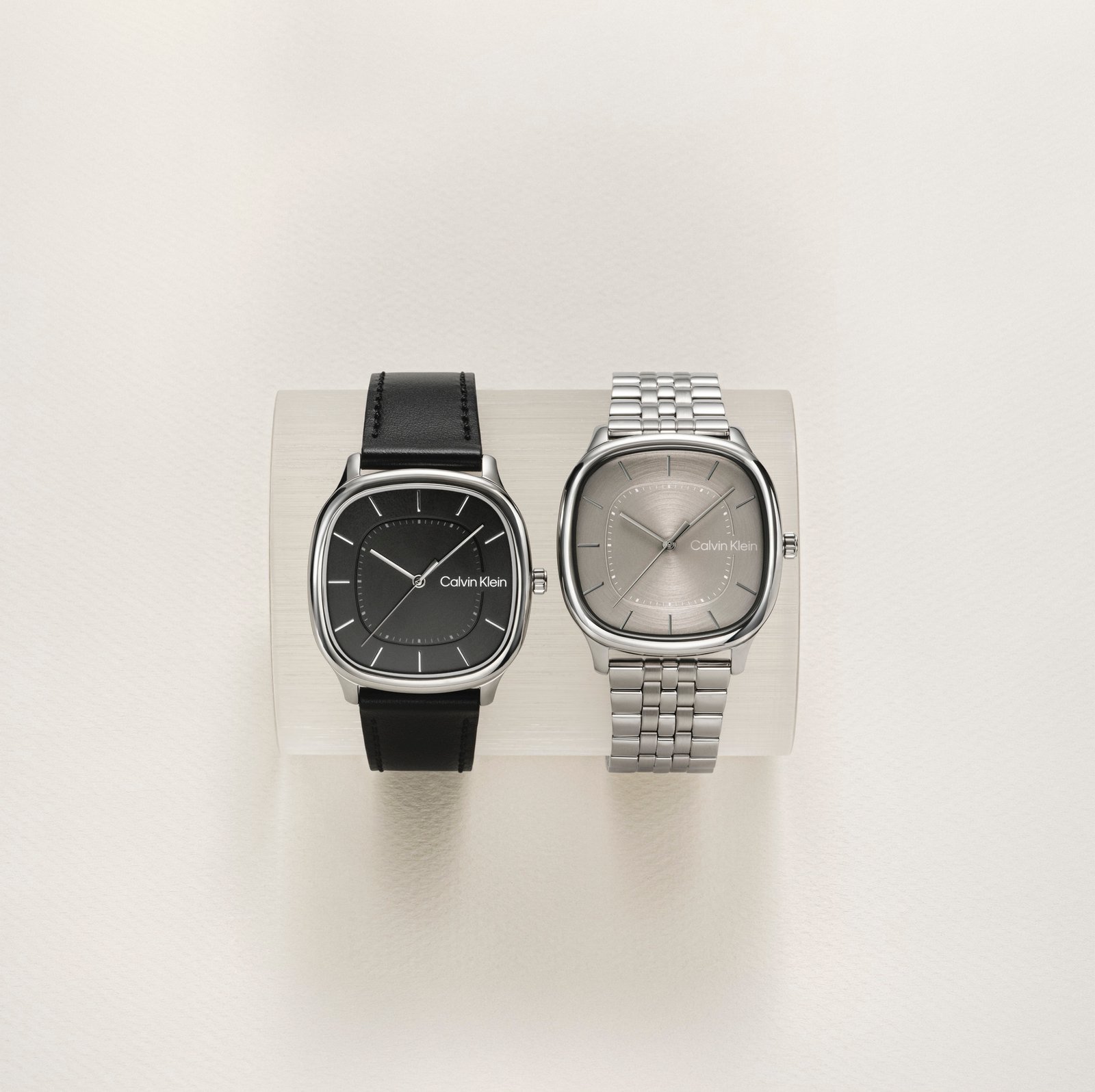 Dois relógios Calvin Klein de caixa quadrada, um com pulseira de couro preto e outro com bracelete de aço