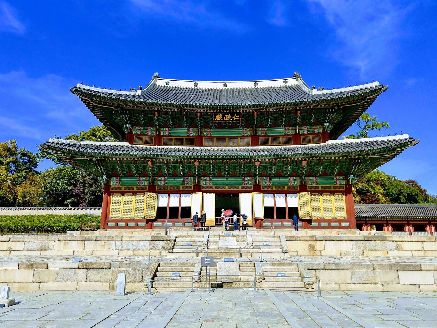 Pavilhão Injeongjeon, salão do trono do Palácio Changdeokgung, em Seul, com telhado duplo verde e portas amarelas sob céu azul