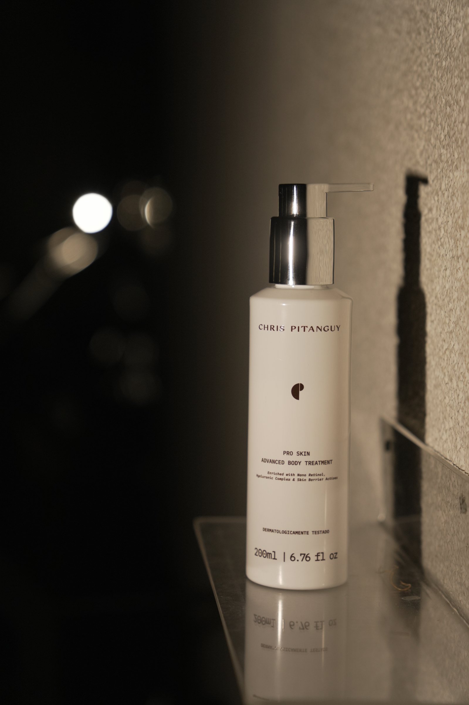 Frasco do Advanced Body Skin Treatment, da Chris Pitanguy Labs, sobre fundo escuro