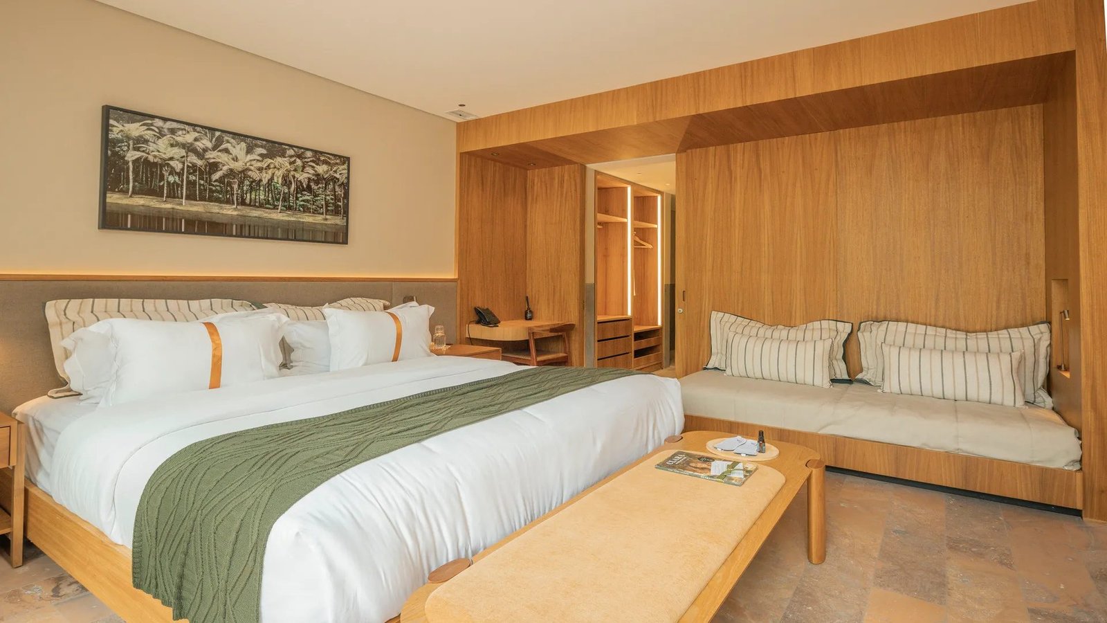 Suíte Luxo do Clara Arte com cama king-size, sofá-cama e painéis de madeira