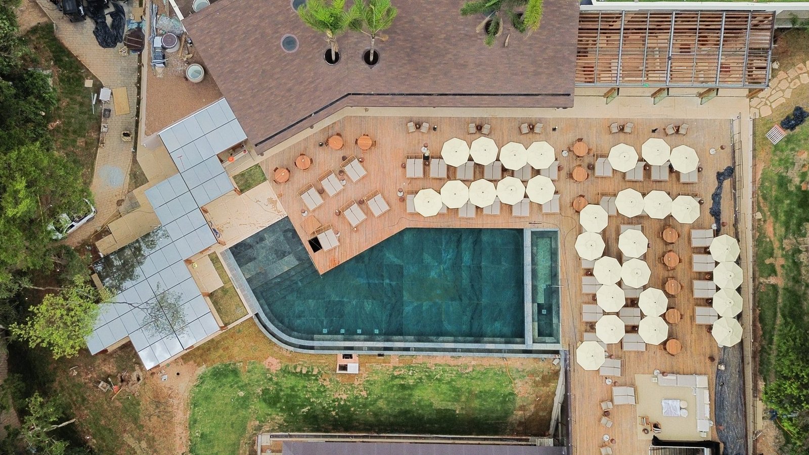 Vista aérea do Clara Arte, com piscina externa, deck e mata ao redor