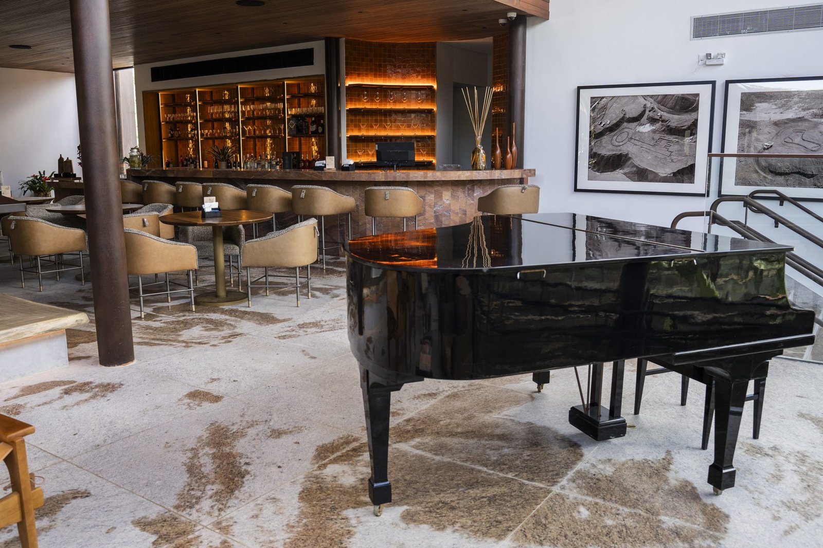 Bar do Clara Arte com balcão iluminado, poltronas de couro e piano de cauda