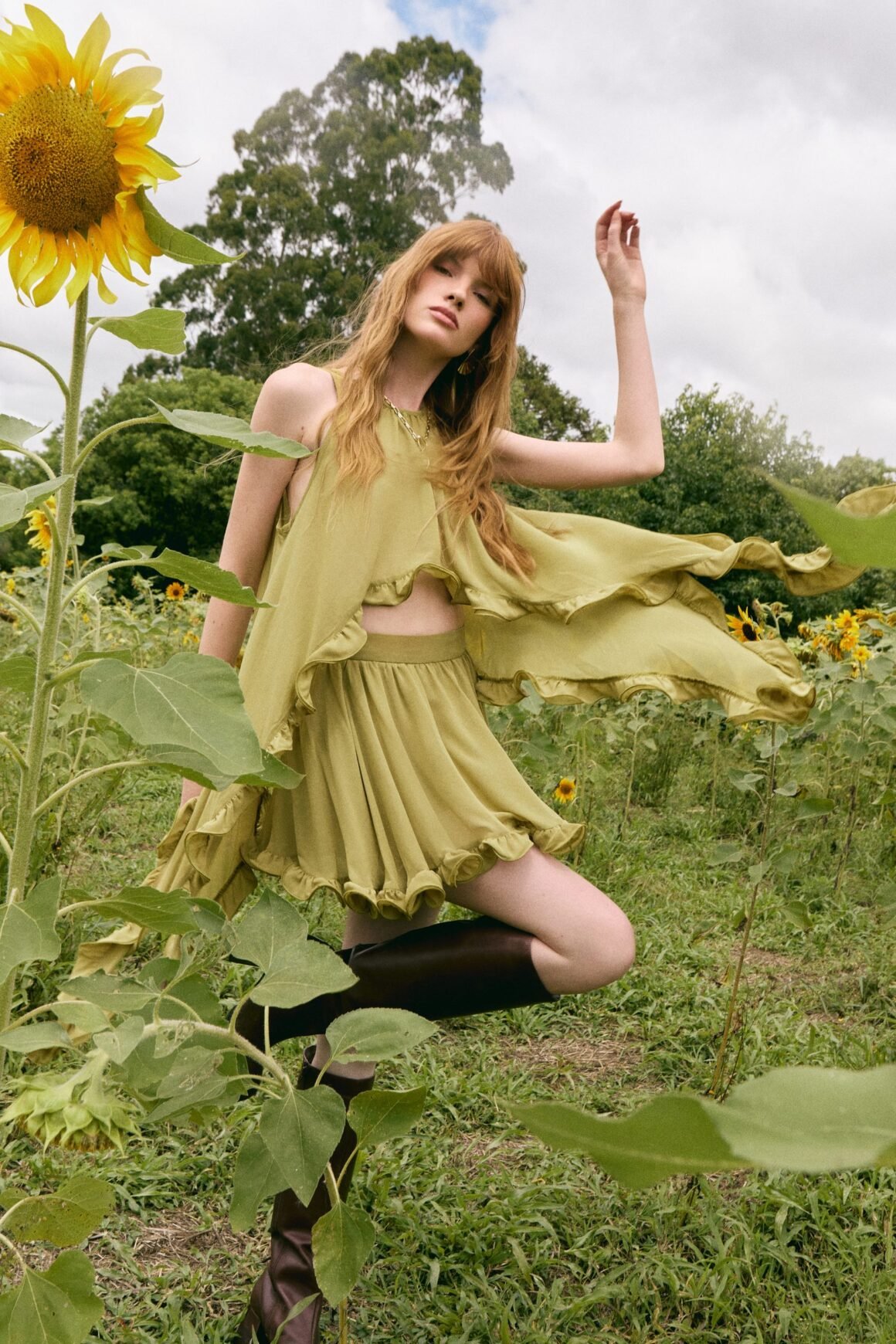 Modelo veste conjunto em verde com babados da Litt em um campo de girassóis