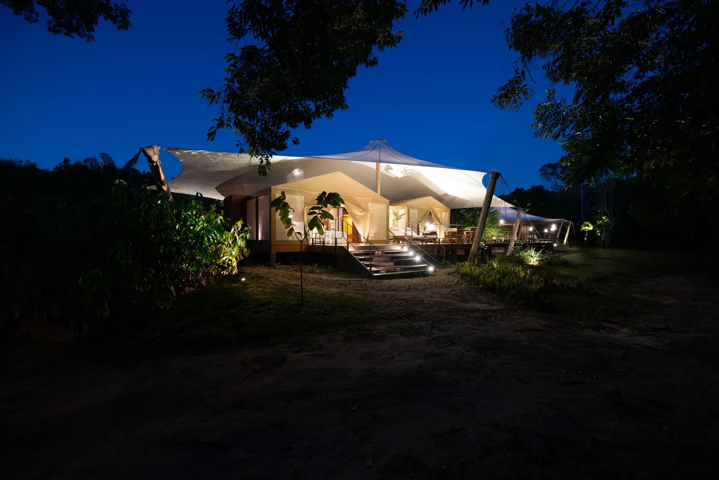 Cristalino Camp tented suite lit at night in the Amazon forest