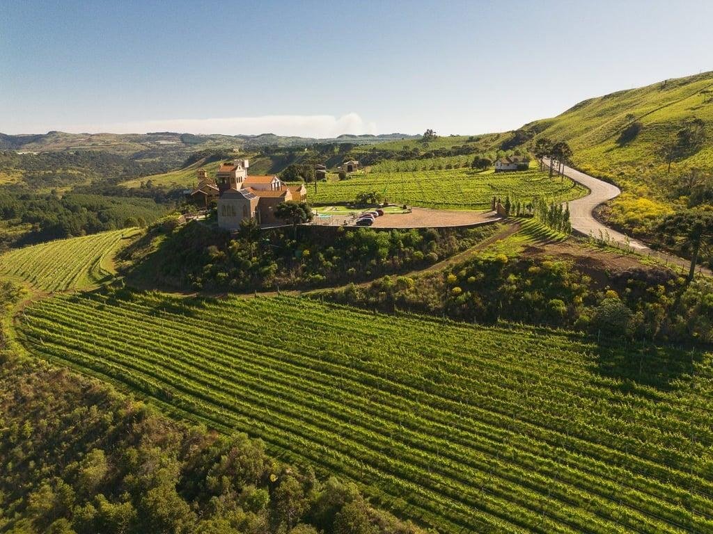 Vista aérea de vinícola no alto de um morro cercado por parreirais, em São Joaquim, na Serra Catarinense