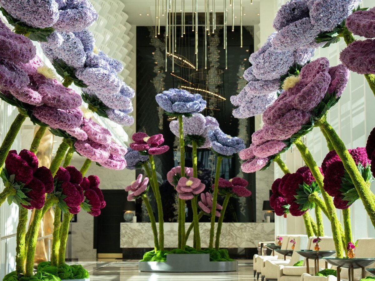 Instalação de flores gigantes em tons de roxo, lilás e vinho no lobby do Four Seasons Hotel Abu Dhabi