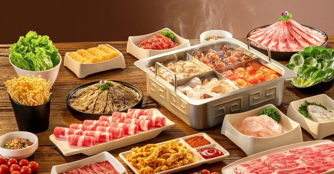 Mesa de hot pot da Haidilao com caldos em panela dividida, carnes fatiadas e vegetais