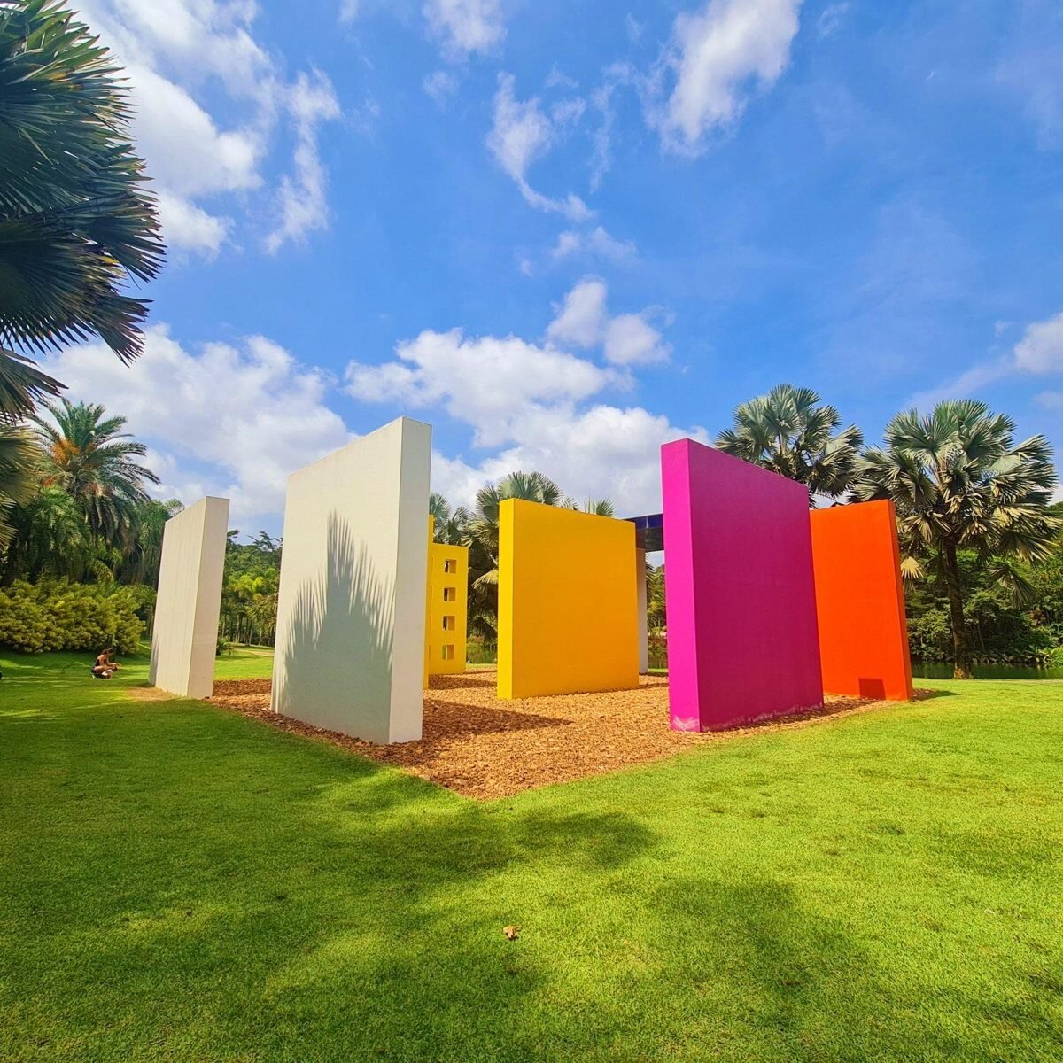 Colourful walls of a contemporary art installation in the gardens of Inhotim, surrounded by palm trees