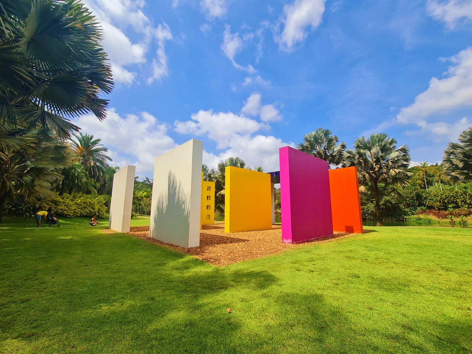 Colourful walls of a contemporary art installation in the gardens of Inhotim, surrounded by palm trees
