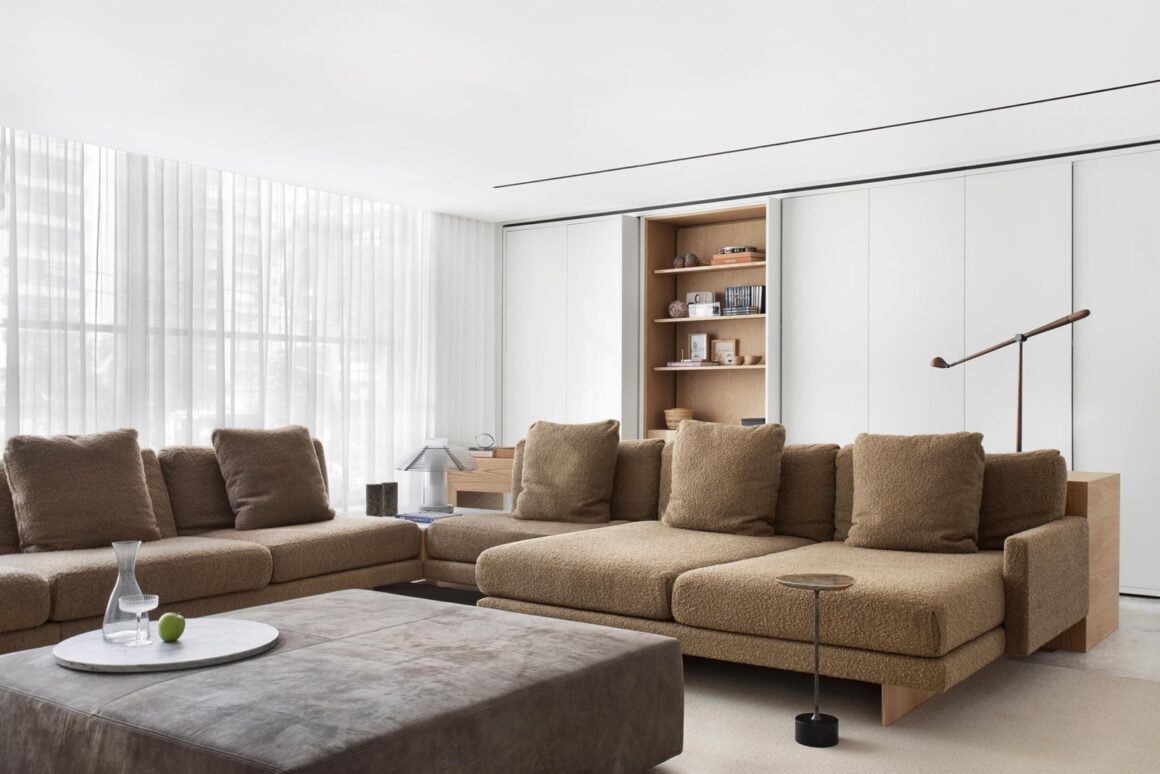 Living room with a large bouclé sectional sofa and wood details in a Jader Almeida interior