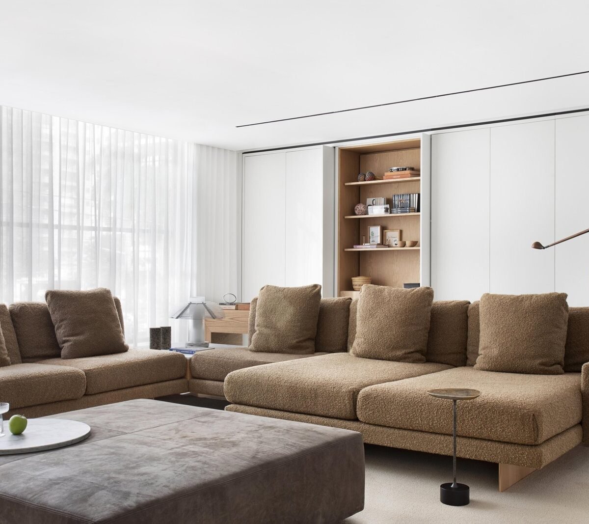 Living room with a large bouclé sectional sofa and wood details in a Jader Almeida interior