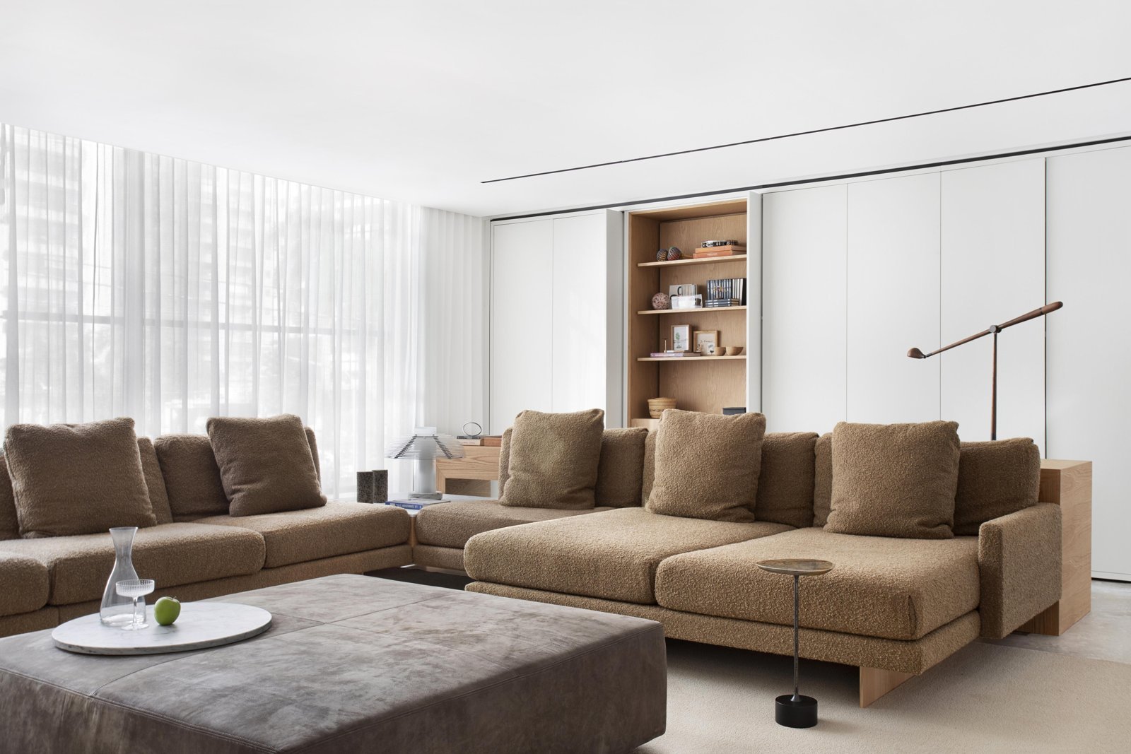 Living room with a large bouclé sectional sofa and wood details in a Jader Almeida interior