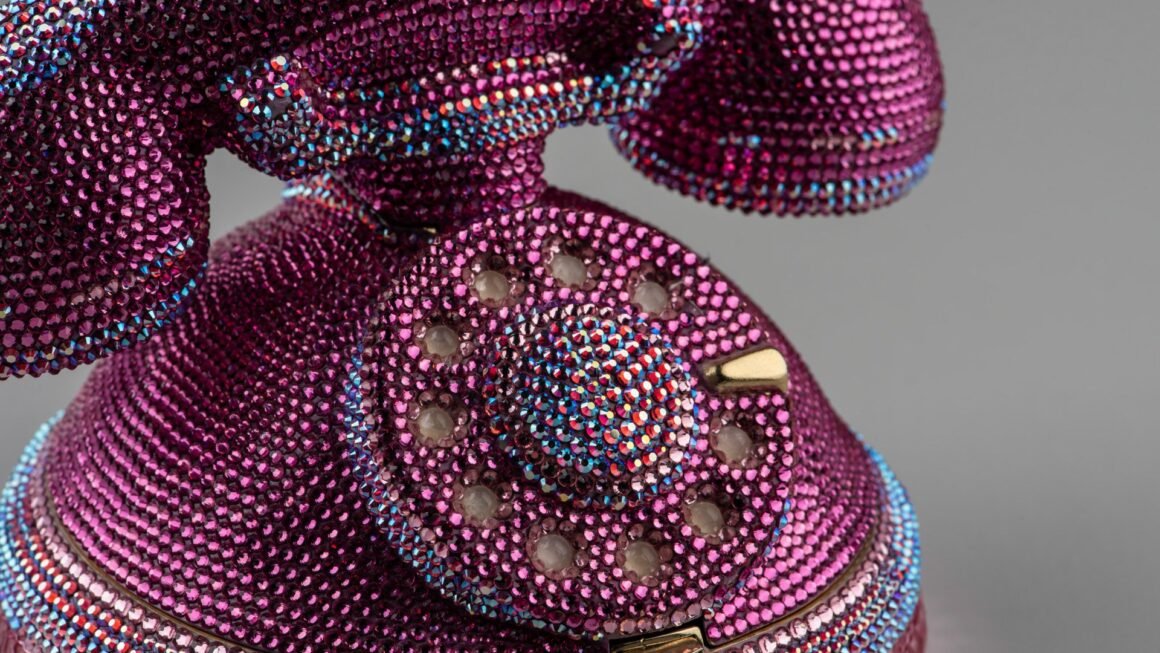 Minaudière de Judith Leiber em forma de telefone, coberta de cristais rosa