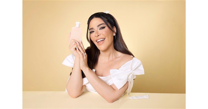 Mona Kattan segura o frasco de Yum Vanilla Cupcake 108 em campanha da KAYALI.