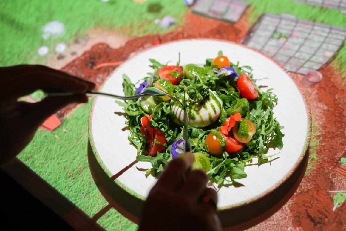 Salada servida sobre projeção de jardim na mesa do Le Petit Chef