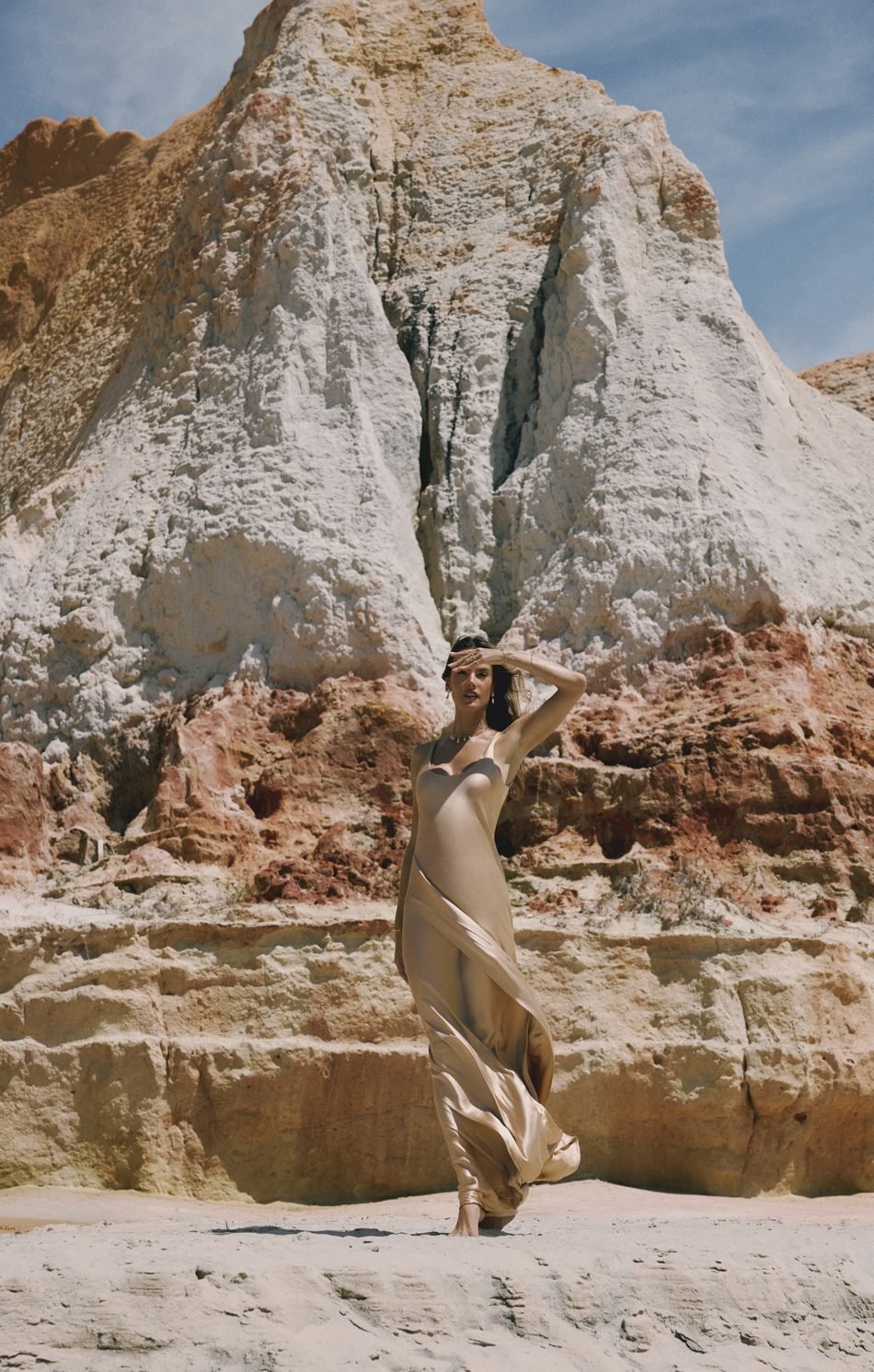 Alessandra Ambrosio em vestido acetinado dourado diante das falésias de Beberibe, no Ceará, na campanha Feitas de Luz da Morana
