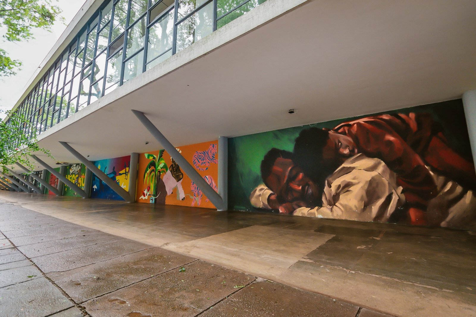 Fachada do Museu Afro Brasil Emanoel Araujo, sob a marquise do Ibirapuera, com murais coloridos pintados ao longo da parede