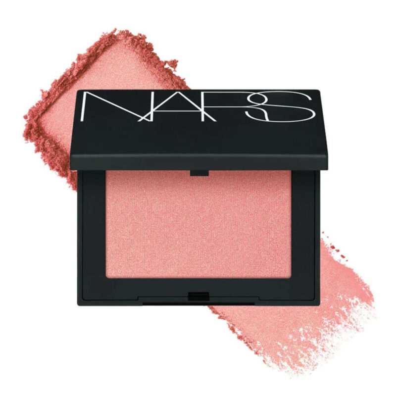 Estojo preto do blush Nars Orgasm aberto, com pó rosa pêssego e um borrão do pigmento ao fundo