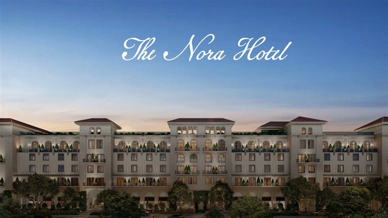 Fachada do The Nora Hotel ao entardecer, com o nome do hotel sobre o céu