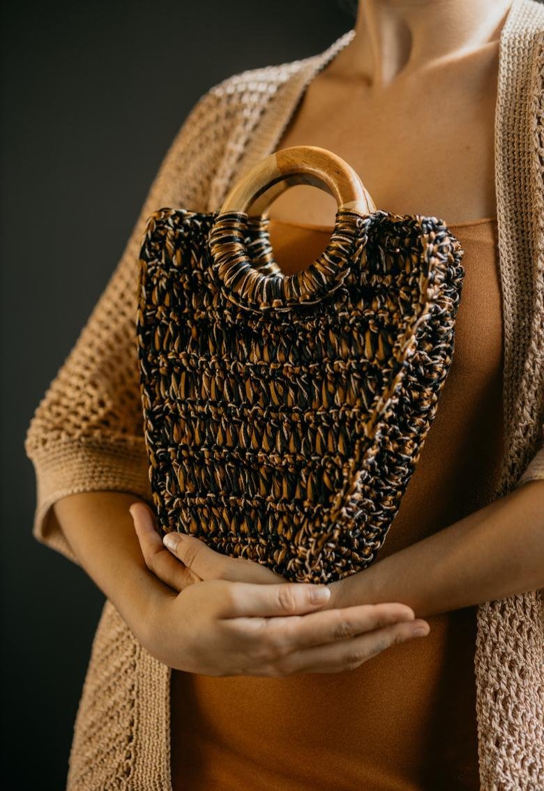 Catarina Mina crochet bag in black and caramel tones with a round wooden handle