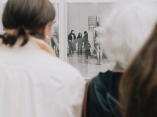 Visitantes observam fotografia em preto e branco na Paris Photo 2025, no Grand Palais