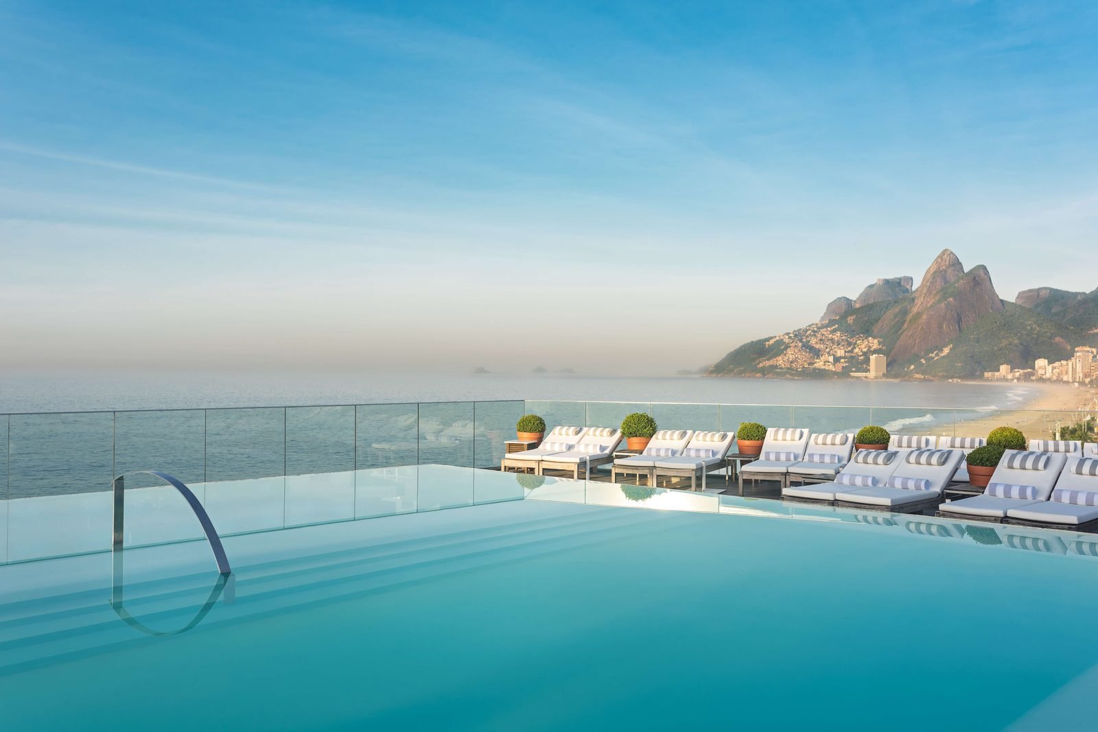 Piscina de borda infinita no rooftop do Fasano Rio de Janeiro, com a Praia de Ipanema e o Morro Dois Irmãos ao fundo