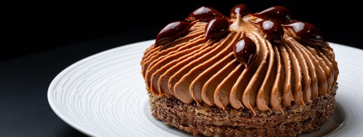 Doce de chocolate com mousse e gotas de caramelo servido em prato branco