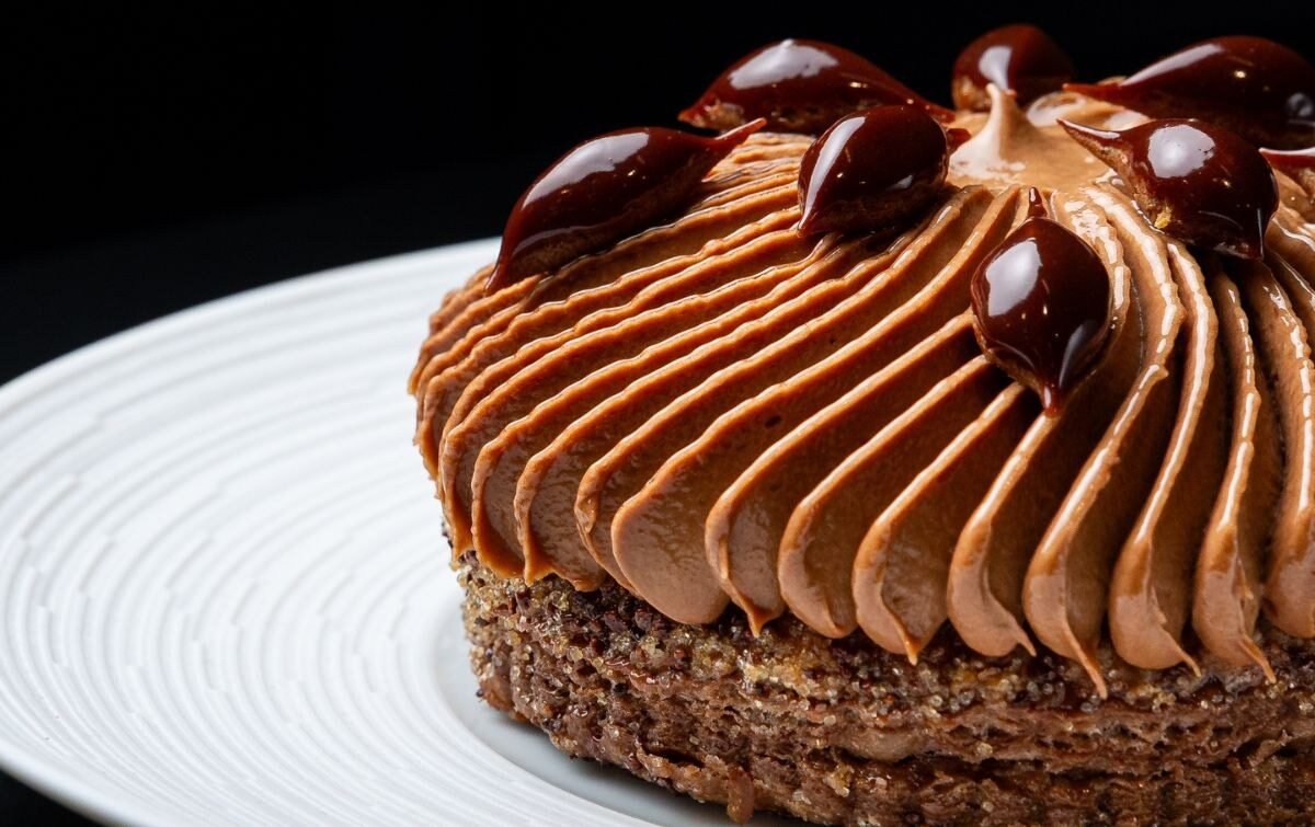Doce de chocolate com mousse e gotas de caramelo servido em prato branco