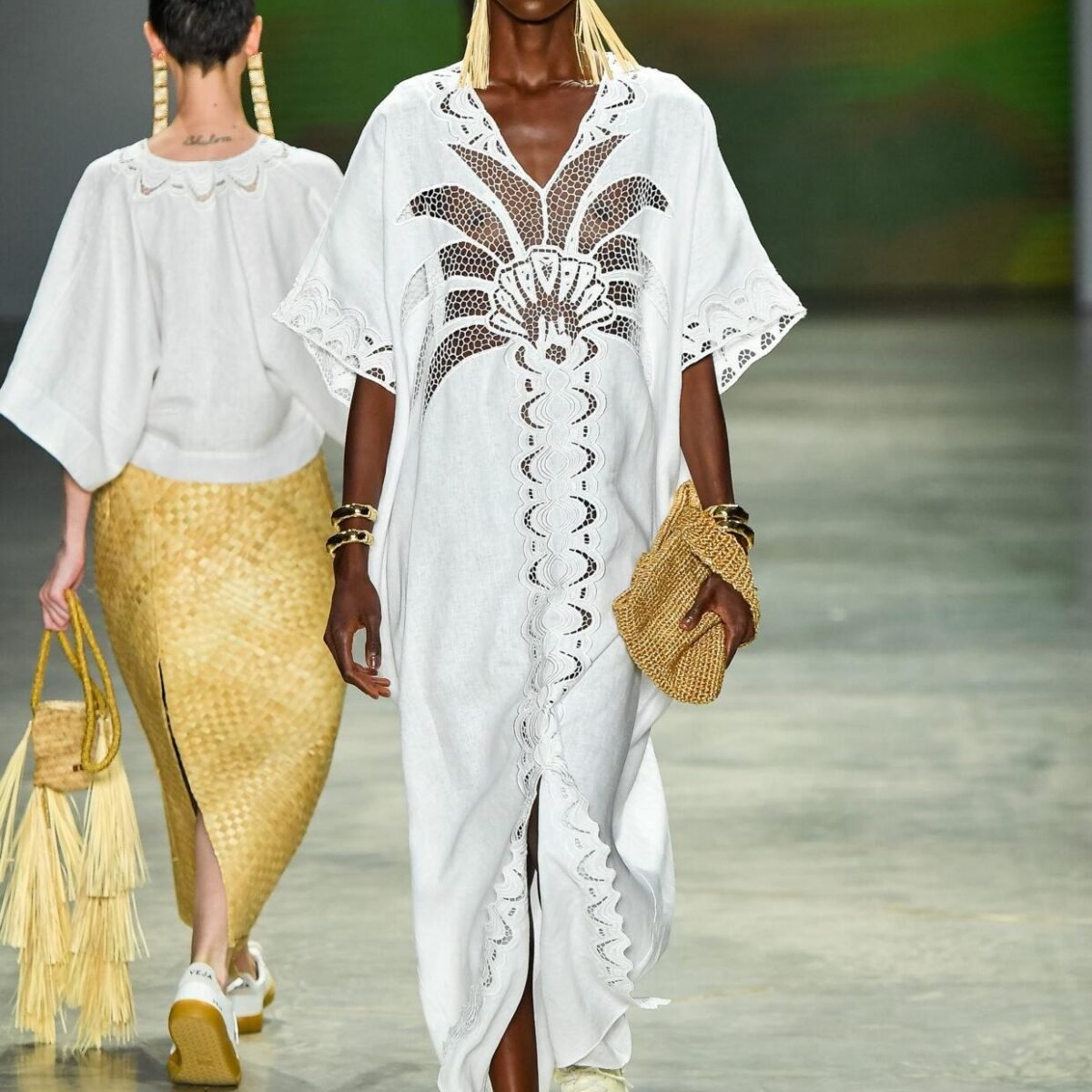 Modelo desfila com vestido longo de linho branco com bordado vazado e bolsa de palha, da Catarina Mina, no SPFW N61