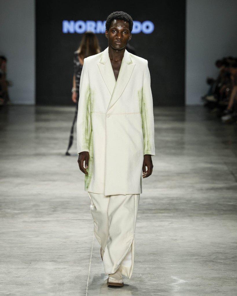 Modelo desfila com casaco longo off-white com pintura verde e calça ampla, da Normando, no SPFW N61