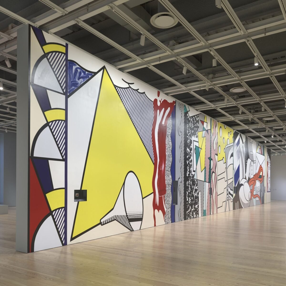 Mural de Roy Lichtenstein com formas amarelas, vermelhas e azuis em sala da exposição Like New, no Whitney Museum