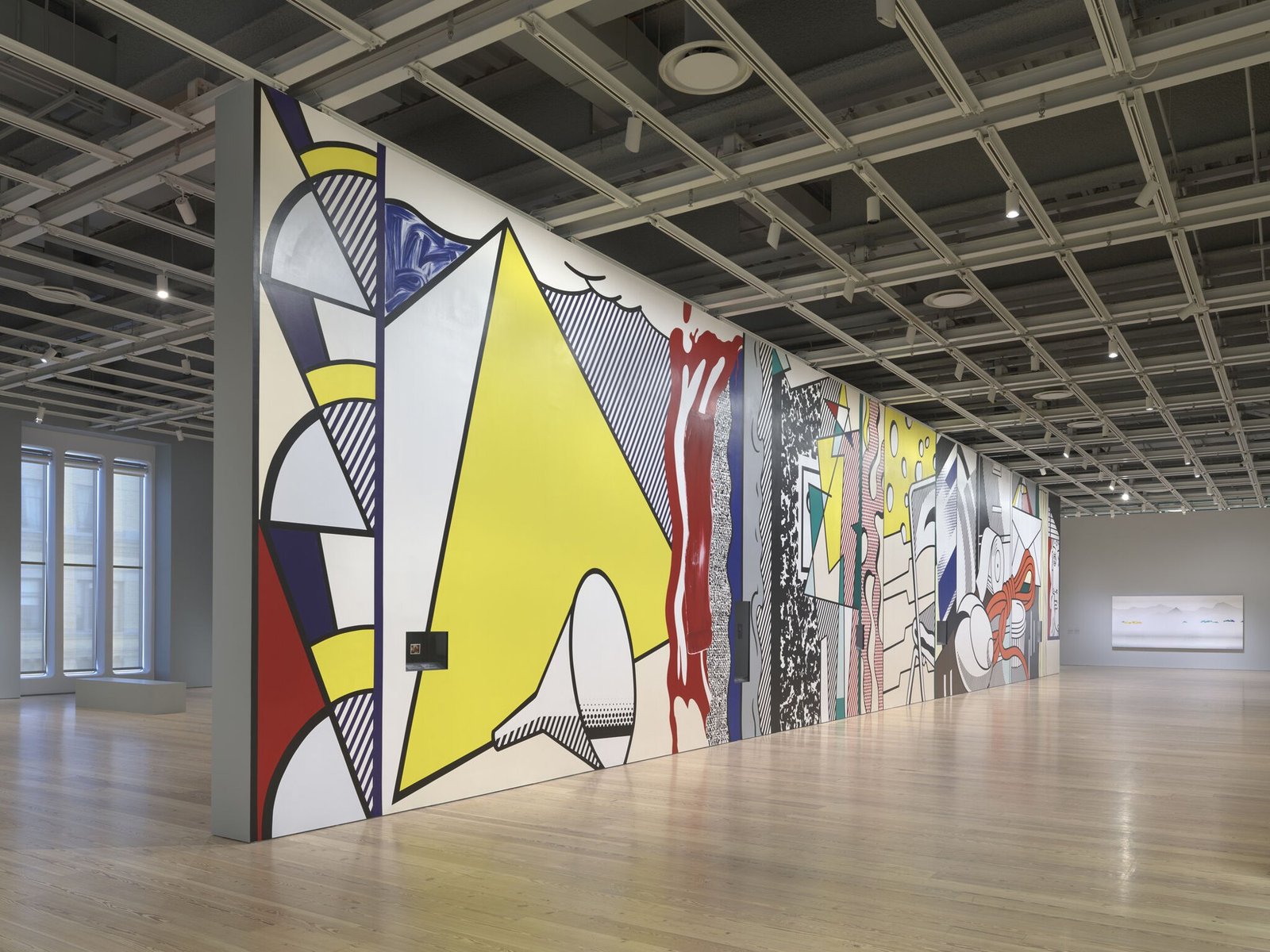 Mural de Roy Lichtenstein com formas amarelas, vermelhas e azuis em sala da exposição Like New, no Whitney Museum
